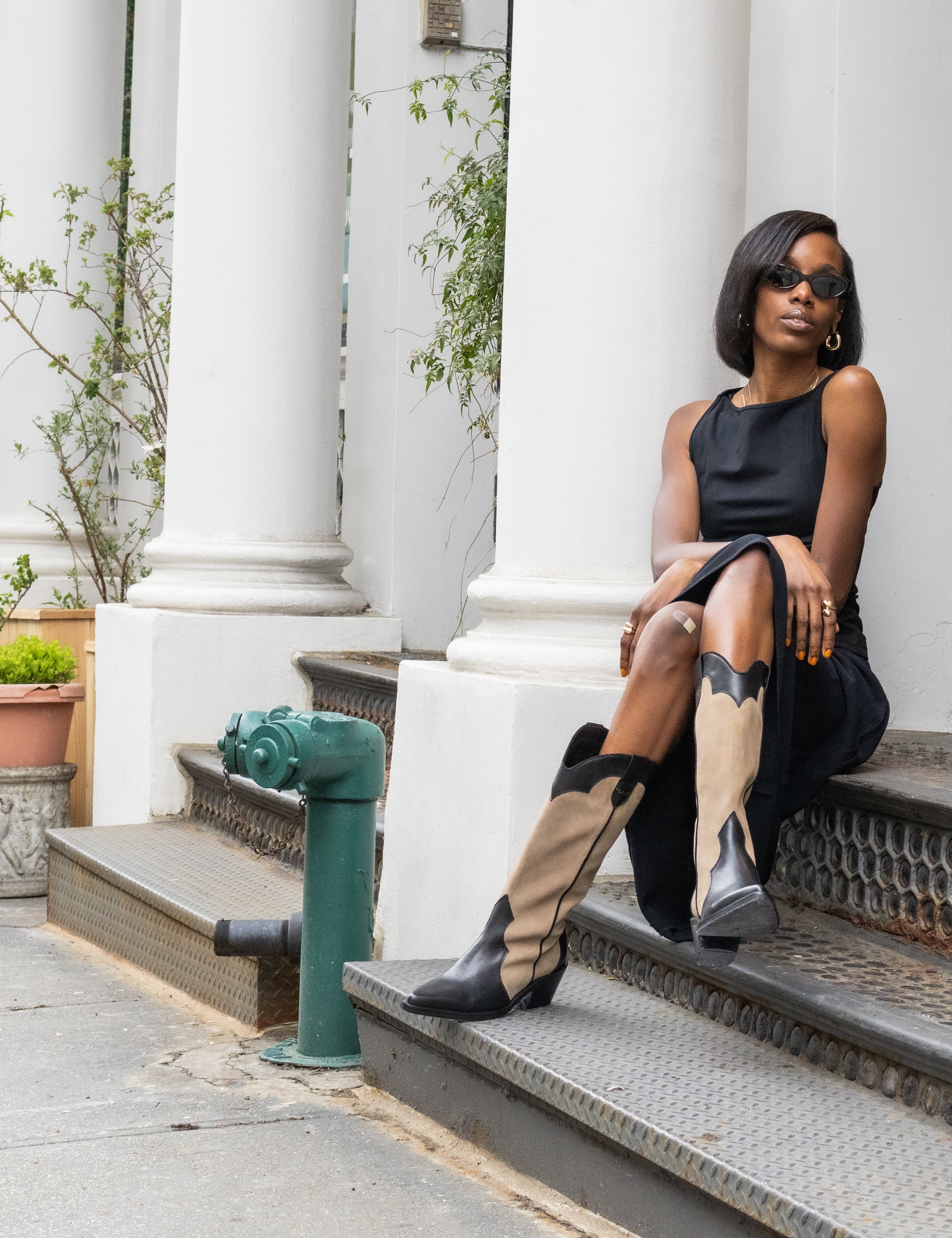Woman sitting on steps in an urban setting with classical architecture