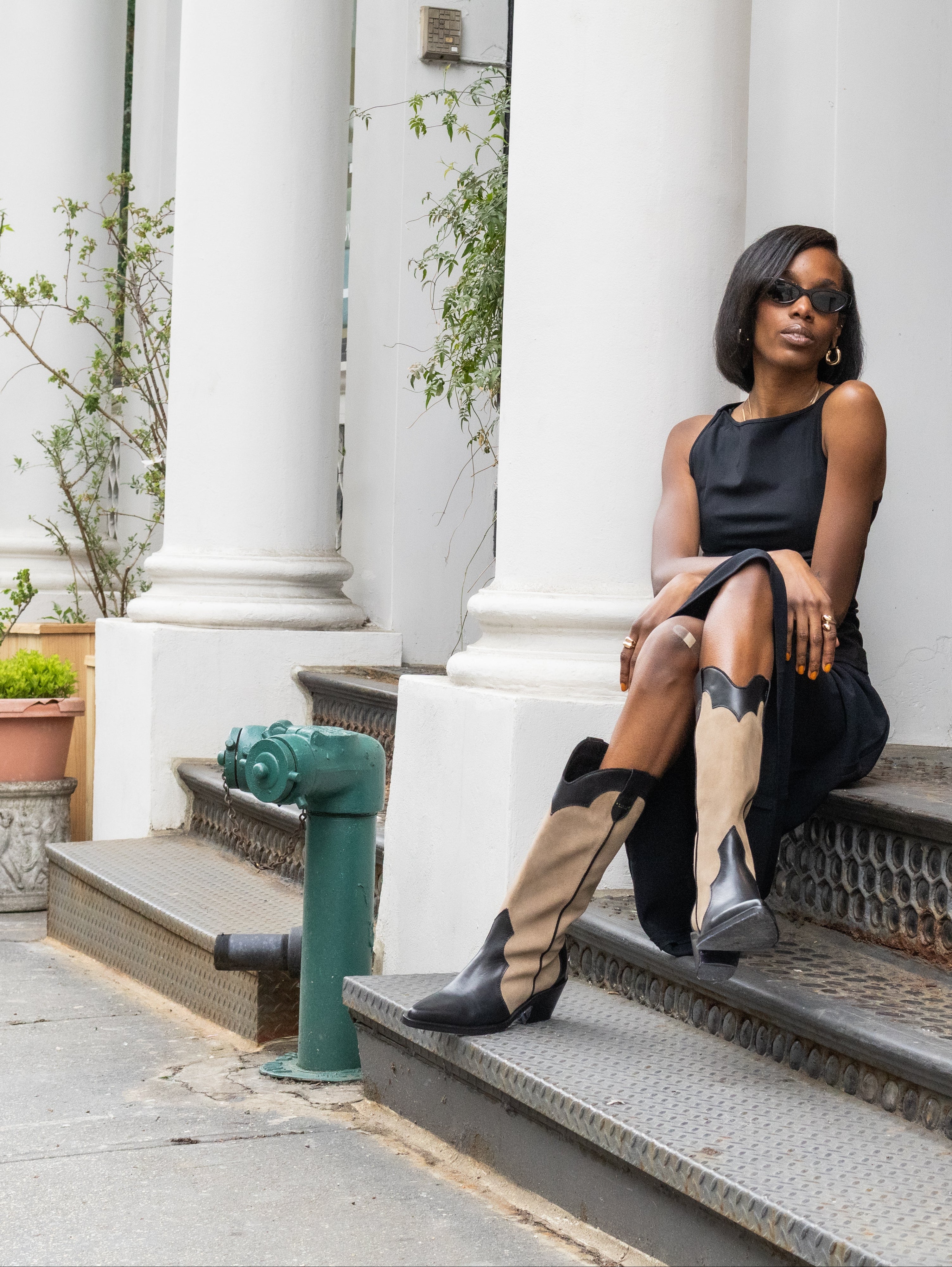 Woman sitting on steps in an urban setting with classical architecture