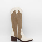 Brown and white cowboy boot on a light gray background