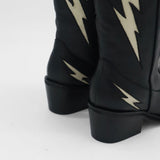 close up detail of black leather kiss with stacked heel and ivory light bolt stitching details 