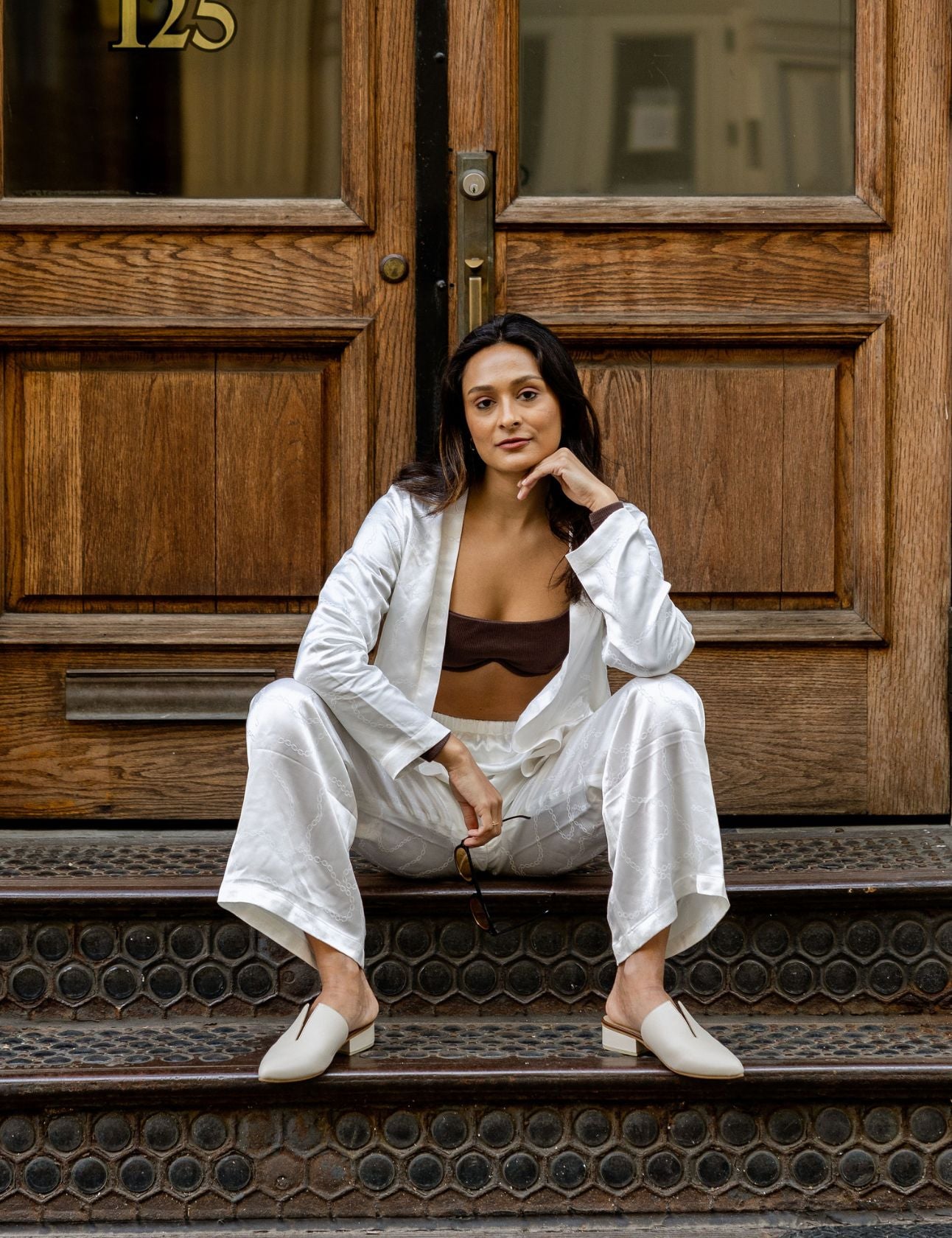 women wearing ivory leather pijao mules with all white linen two piece outfit outdoors in the city