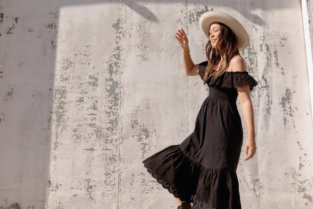 women wearing black leather unstoppable cowboy boots with black maxi dress outdoors 